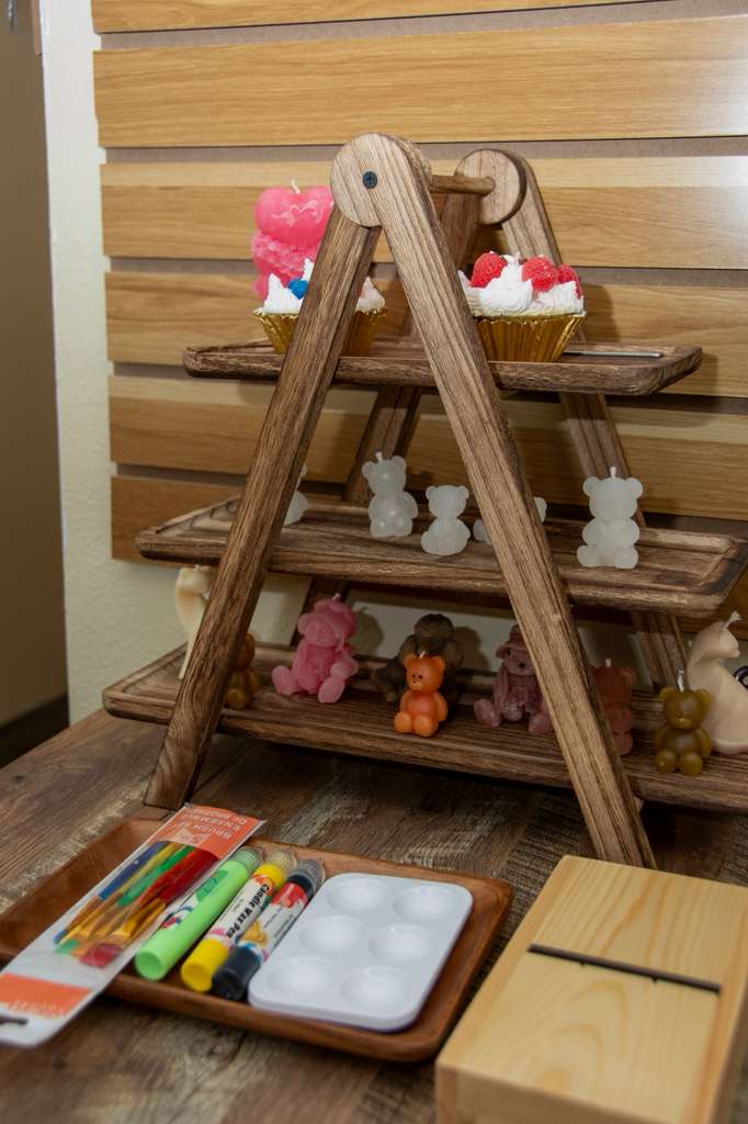 Tiered wooden display of cupcake and bear candles