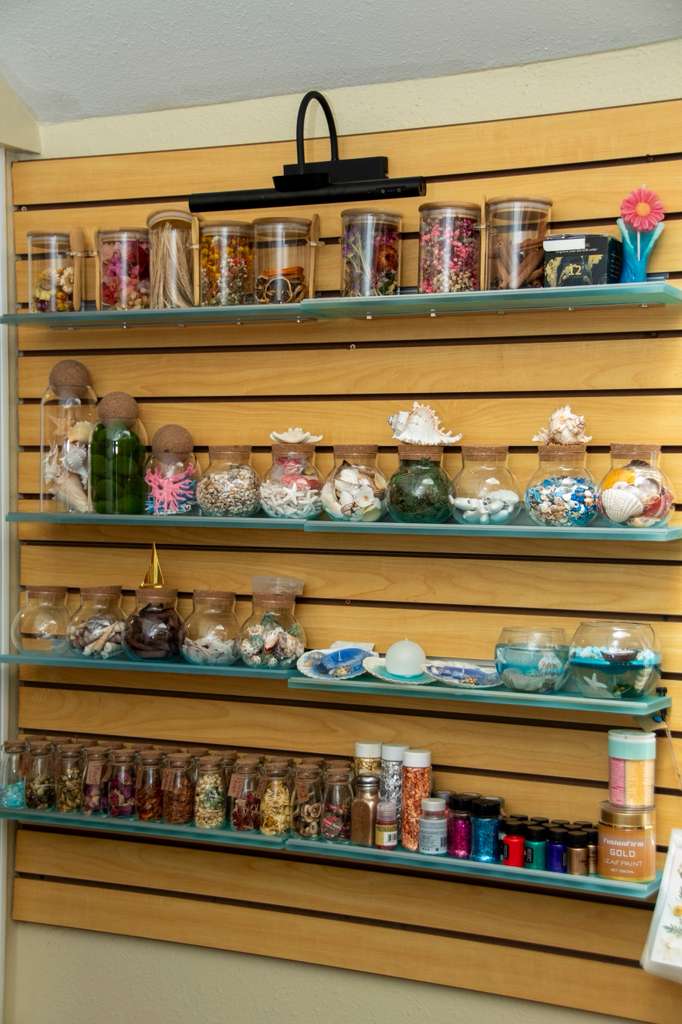 Shelves of jars, botanicals and pigments along the studio wall