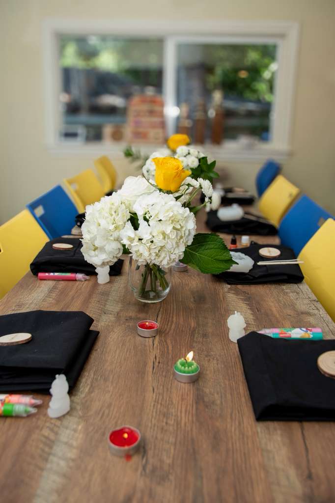 The table set with aprons, tealights and white hydrangeas
